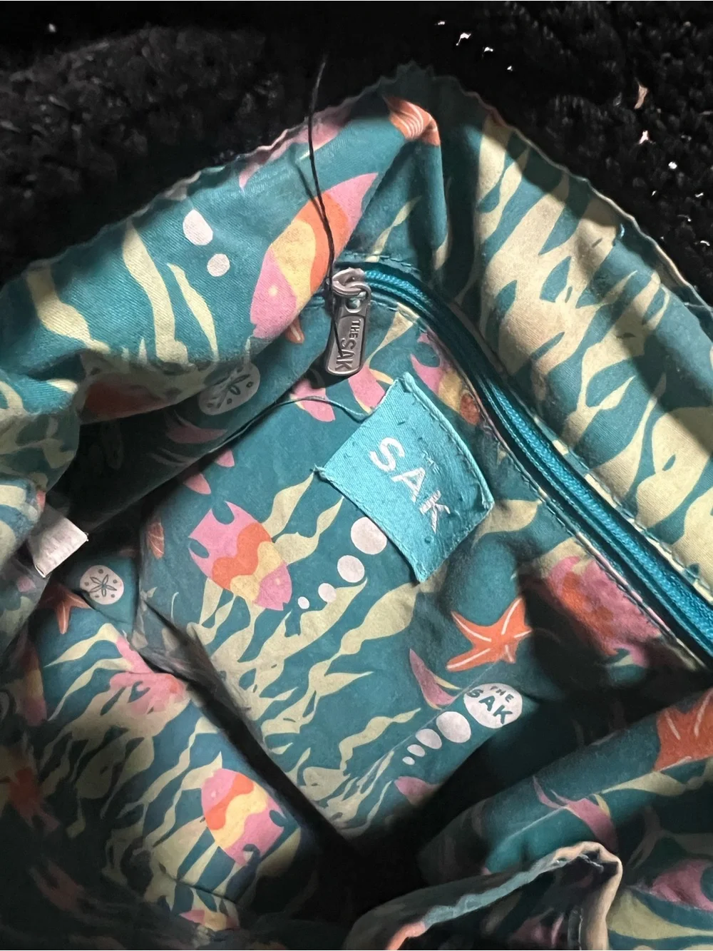 The Sak Black Knit Drawstring Backpack with Pink Floral Charm